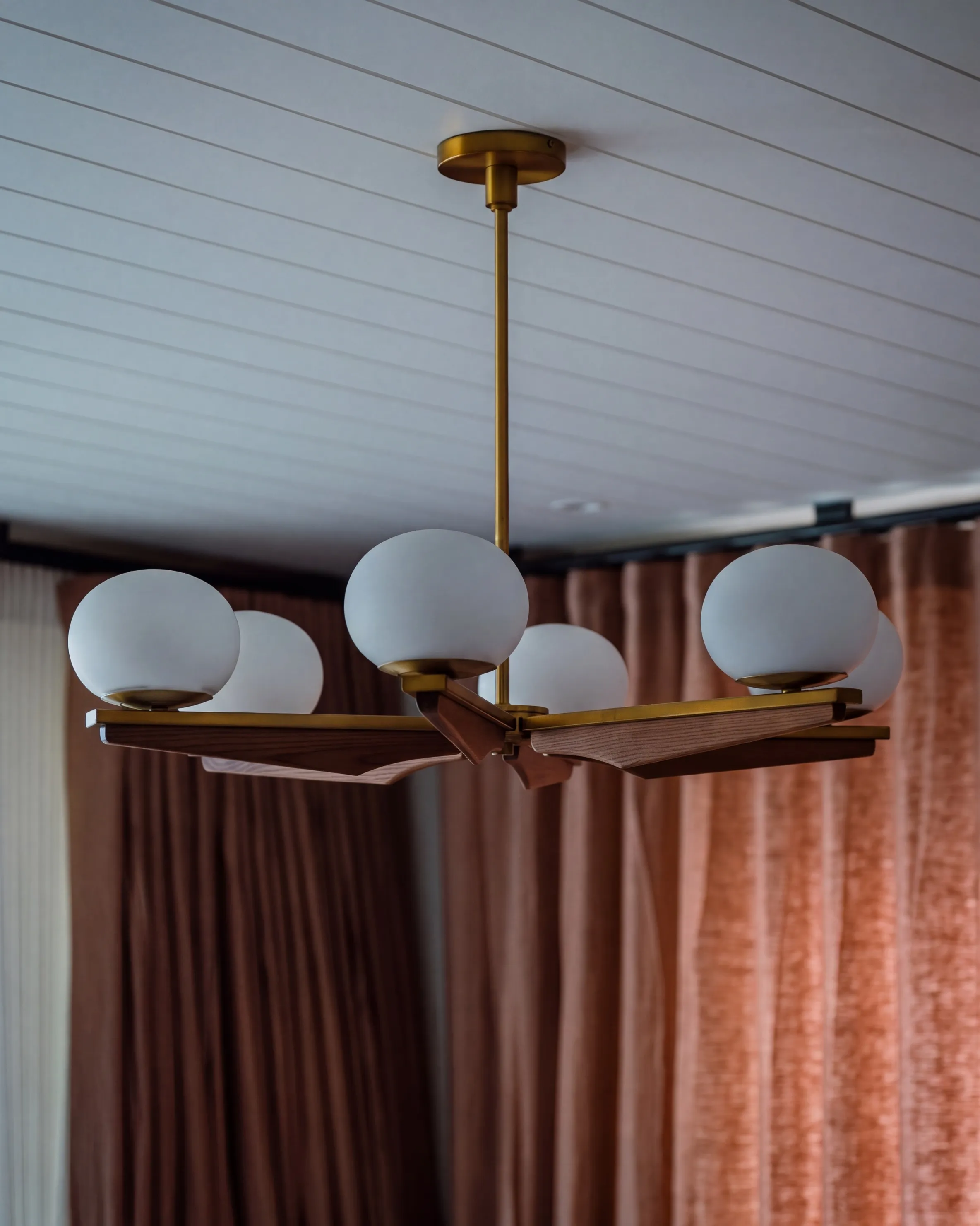 Devonport Villa dining room with a brass chandelier of opal globes
