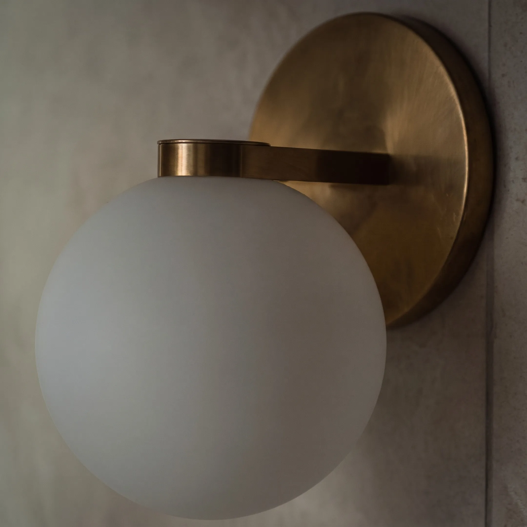 Opal globe wall light on a brass plate, St Marys Bay Villa
